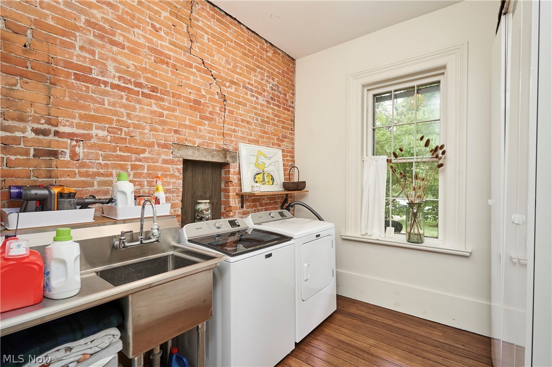 5046 Alger Road Richfield, OH 44286 - Photo 22 of 49 Exposed brick wall with built-in niche, stainless steel utility sink, wood-finish flooring, and a large window with white trim