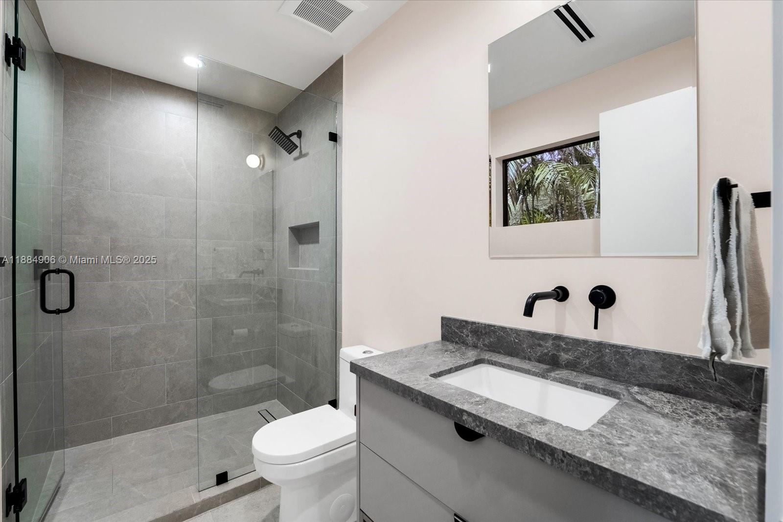 3111 Anderson Road Coral Gables, FL 33134 - Photo 15 of 34 a bathroom with a granite countertop sink a toilet and a mirror