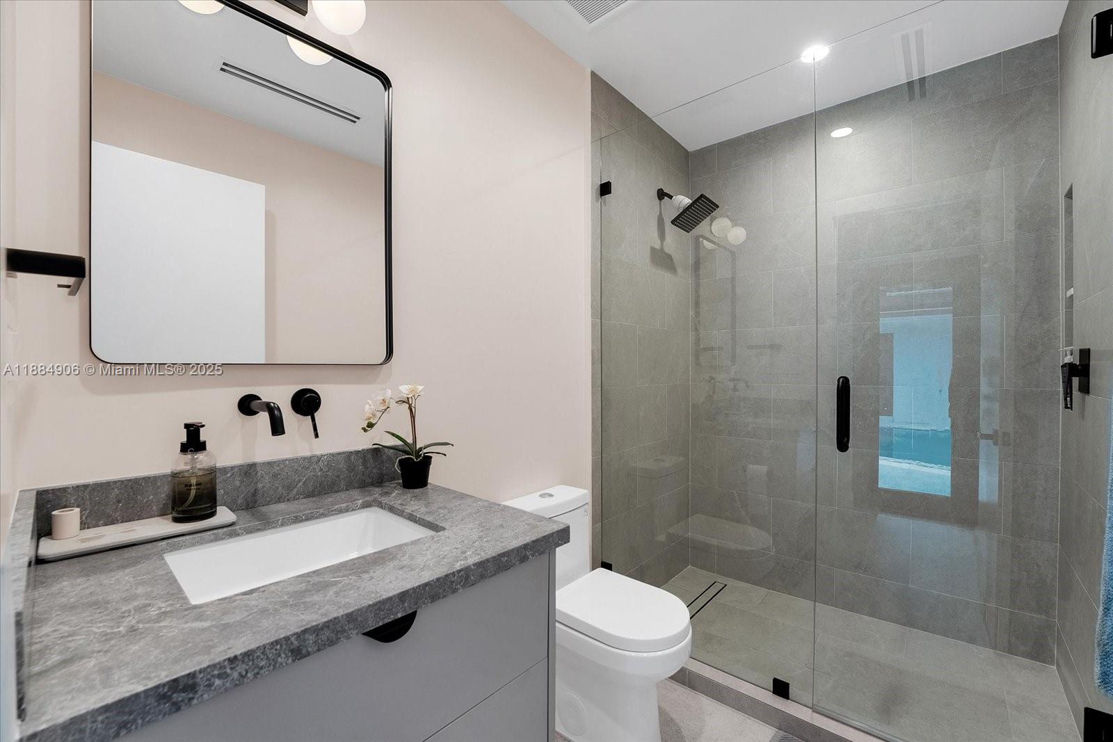 3111 Anderson Road Coral Gables, FL 33134 - Photo 17 of 34 a bathroom with a sink toilet a mirror and shower