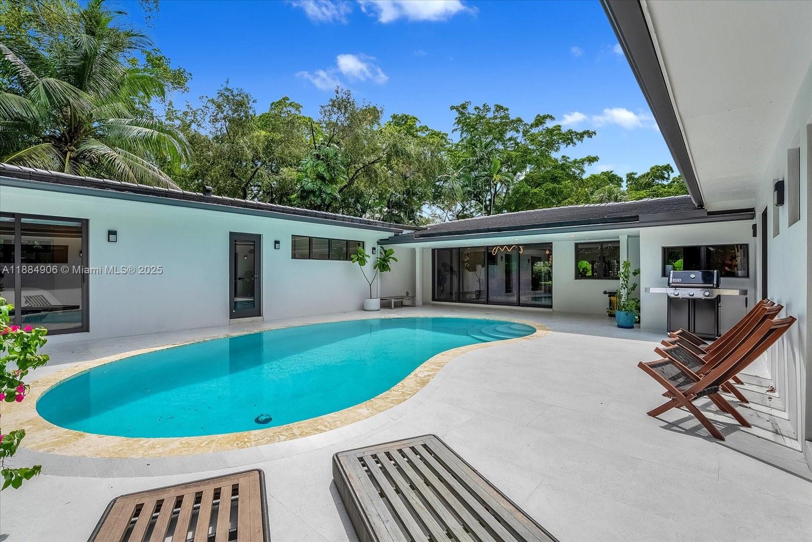 3111 Anderson Road Coral Gables, FL 33134 - Photo 27 of 34 a view of a house with a swimming pool and sitting area