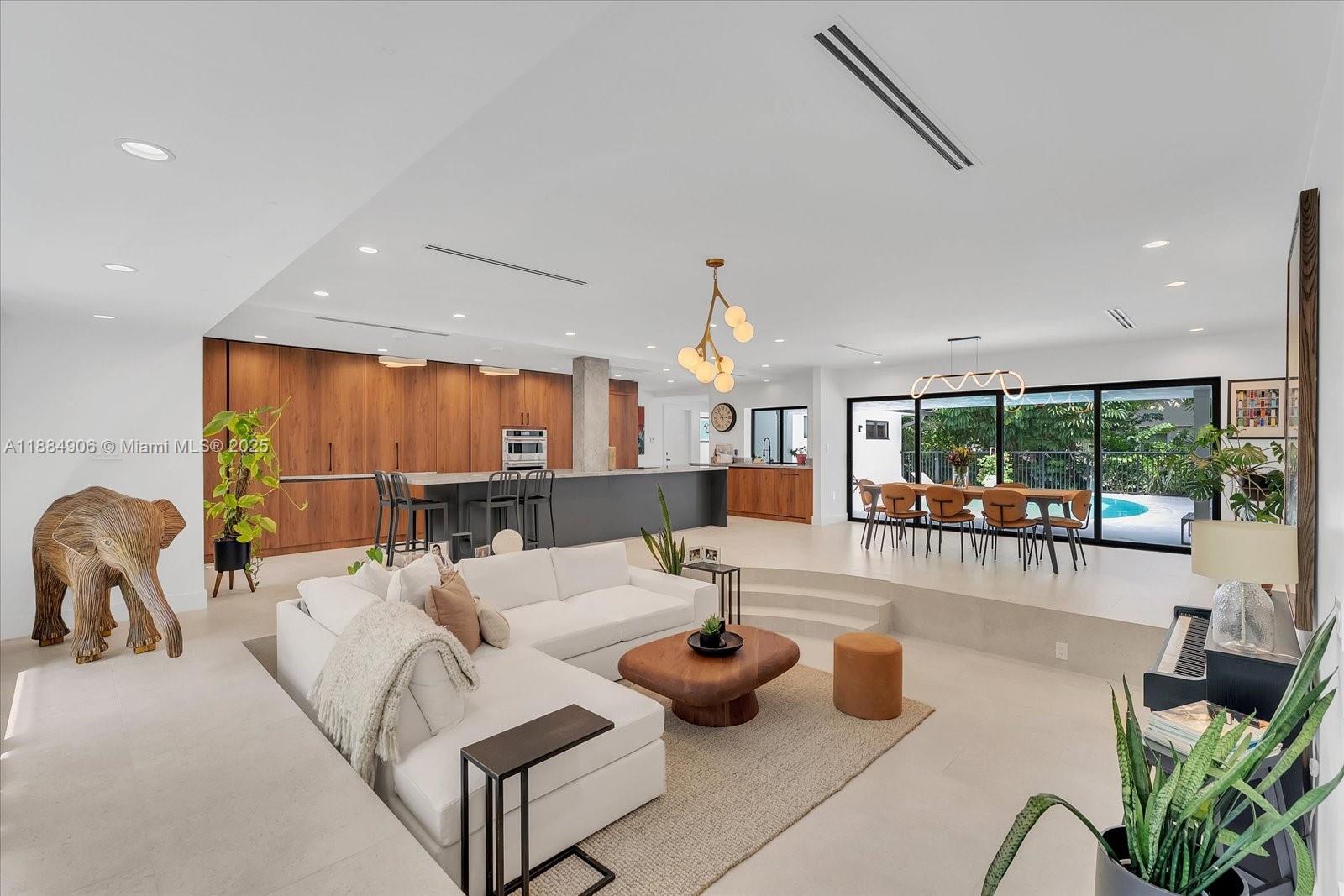 3111 Anderson Road Coral Gables, FL 33134 - Photo 3 of 34 a living room with furniture a large window and a chandelier