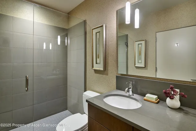 a bathroom with a sink vanity mirror and toilet