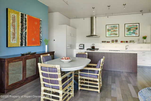 a kitchen with a stove a sink a dining table and chairs