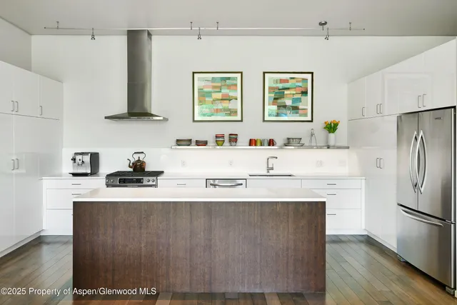 a kitchen with stainless steel appliances a sink a stove a refrigerator and cabinets
