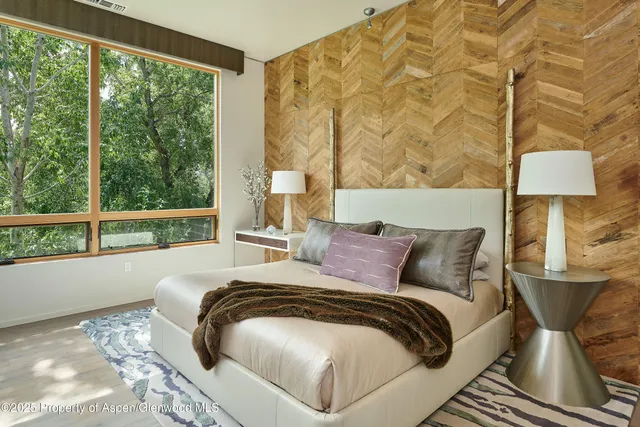 a bed sitting in a bedroom next to a window