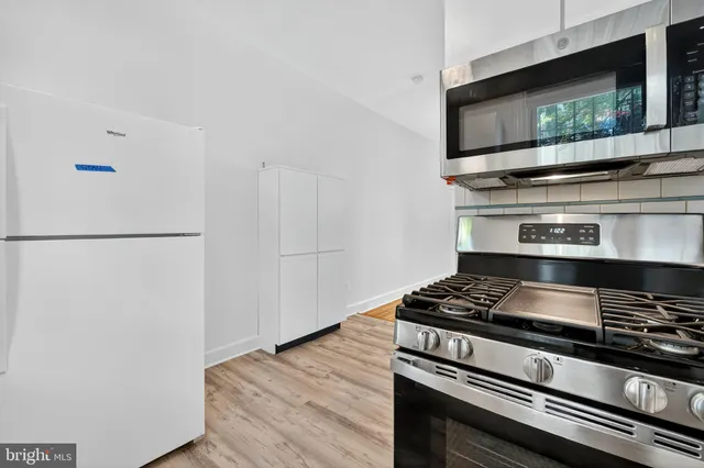 a kitchen with stainless steel appliances a stove and a microwave