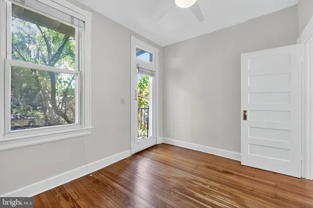 a view of a hallway with wooden floor and staircase