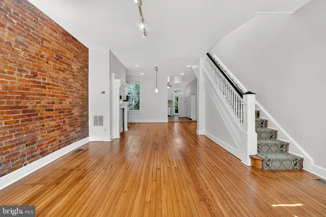 a view of a hallway with wooden floor and staircase