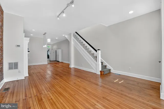 a view of a room with wooden floors and staircase