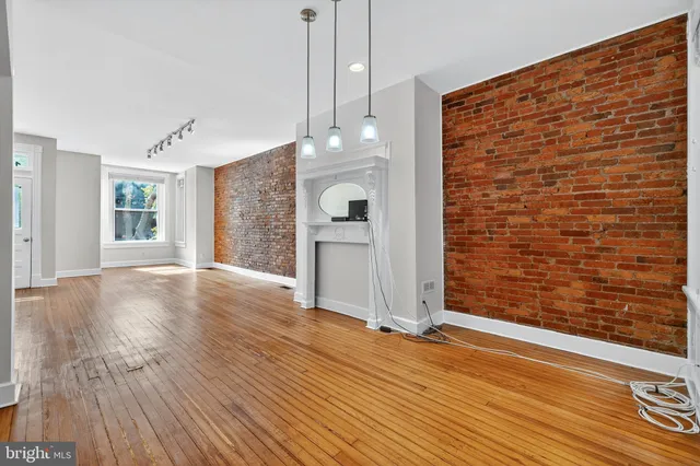 a view of a livingroom with wooden floor and staircase