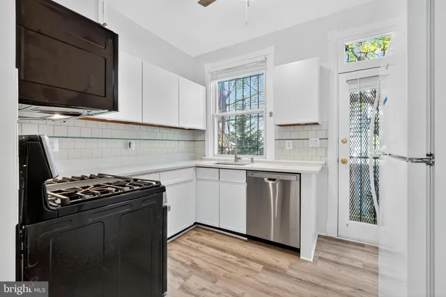 a kitchen with stainless steel appliances a stove a sink and a microwave