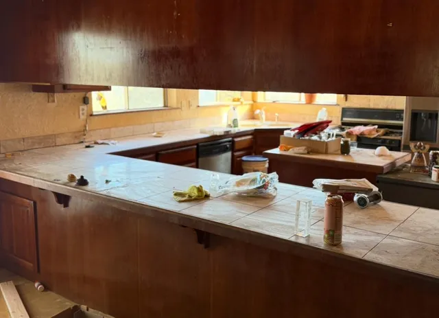 a kitchen with stainless steel appliances kitchen island granite countertop a sink dishwasher stove and cabinets