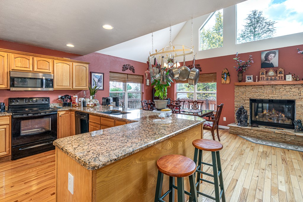 210 Pin Oak Ridge Murphy, NC 28906 - Photo 8 of 51 a kitchen with a stove a kitchen island a sink and a large window