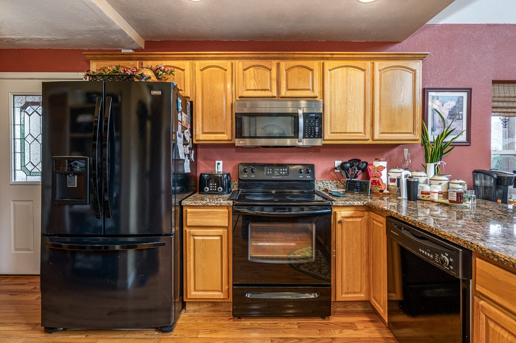210 Pin Oak Ridge Murphy, NC 28906 - Photo 10 of 51 a kitchen with granite countertop a refrigerator stove and microwave