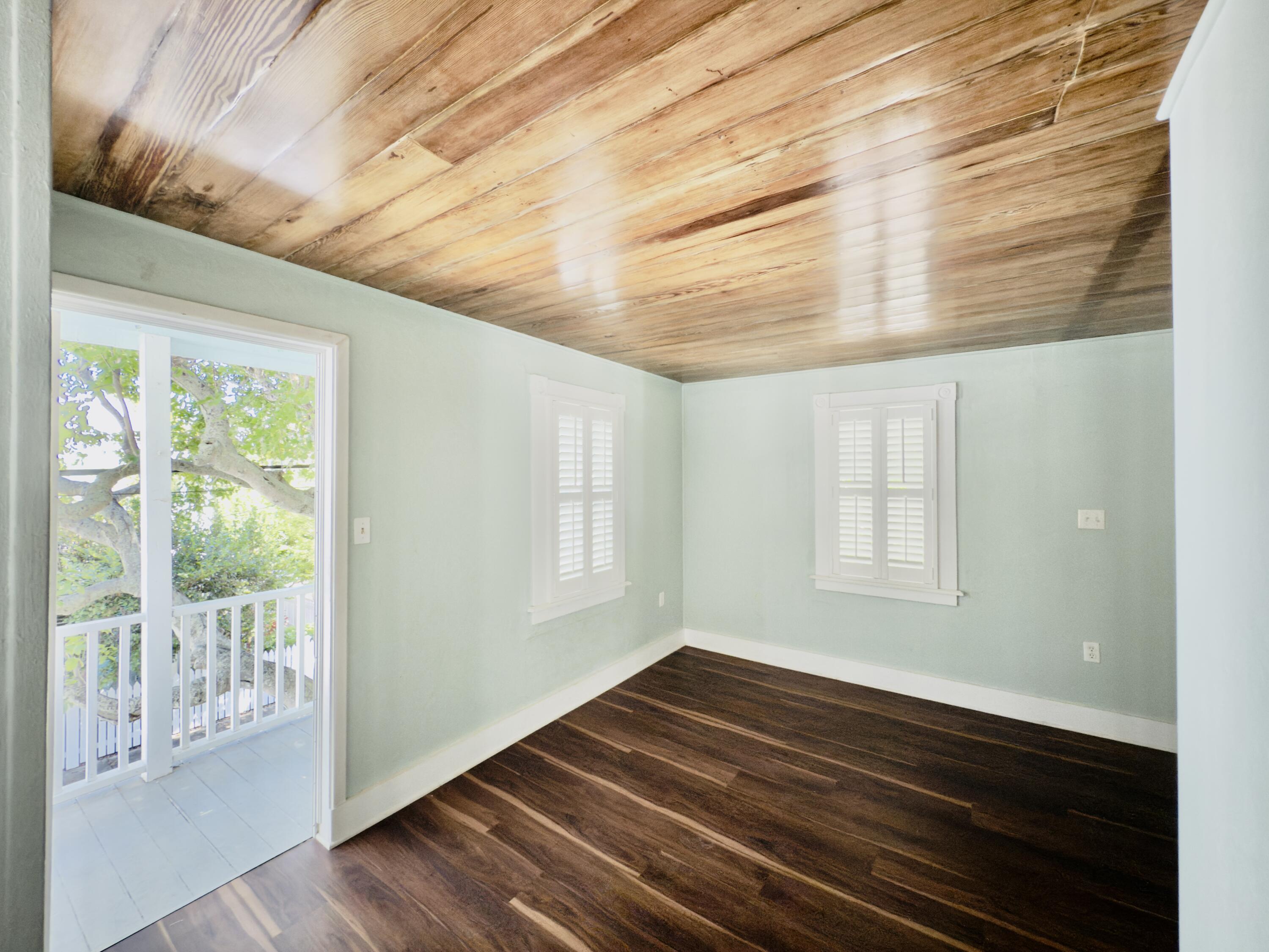 728 Ashe Street Key West, FL 33040 - Photo 21 of 25 a view of an empty room with wooden floor and a window