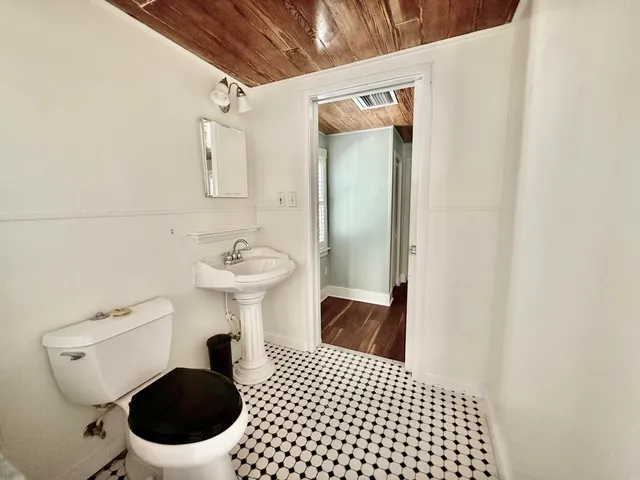 a bathroom with a sink a toilet and a mirror