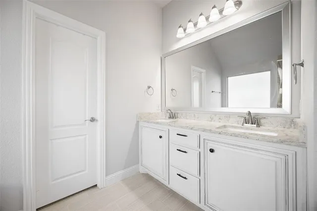 a bathroom with a granite countertop sink double vanity and a mirror