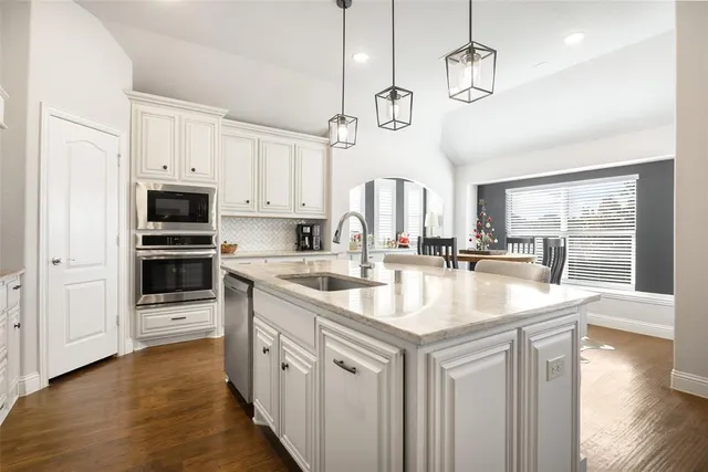 a kitchen with stainless steel appliances granite countertop a sink a oven a stove and a refrigerator