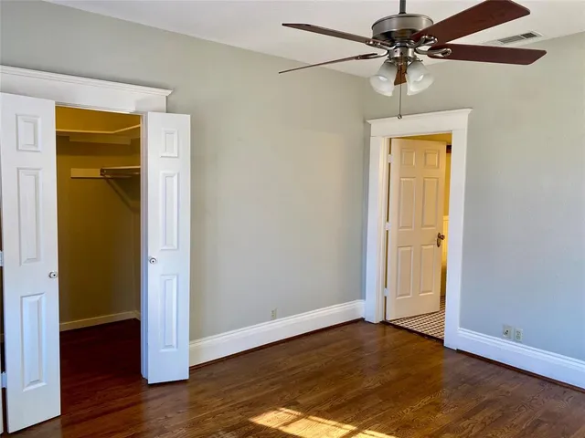 a view of room with wooden floor and ceiling fan