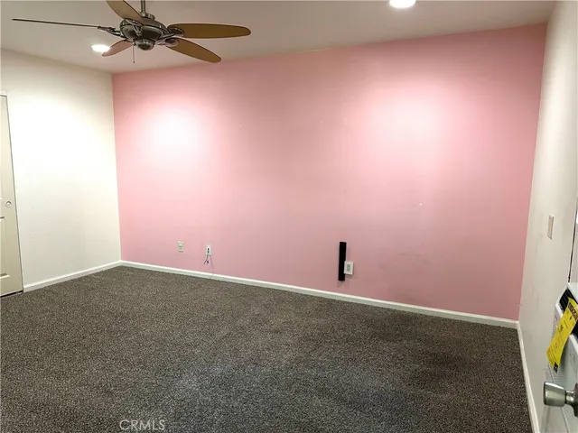 an empty room with a fan and a window