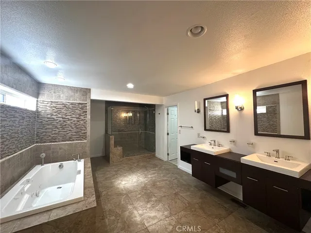 a bathroom with a bathtub a mirror a double vanity sink and