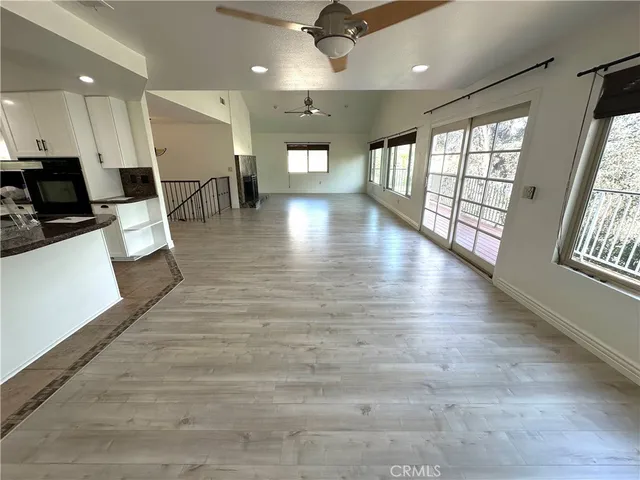 a view of a living room a dining room wooden floor and a large window