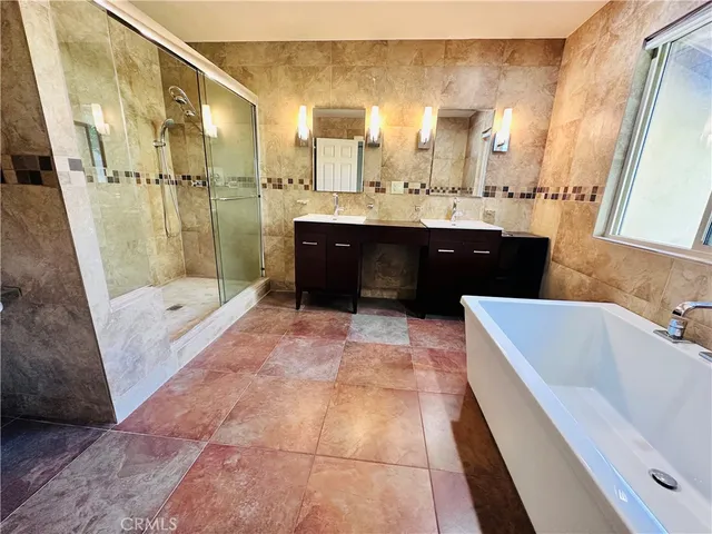 a bathroom with a tub sink and mirror