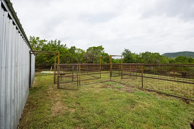 a view of a yard with wooden fence