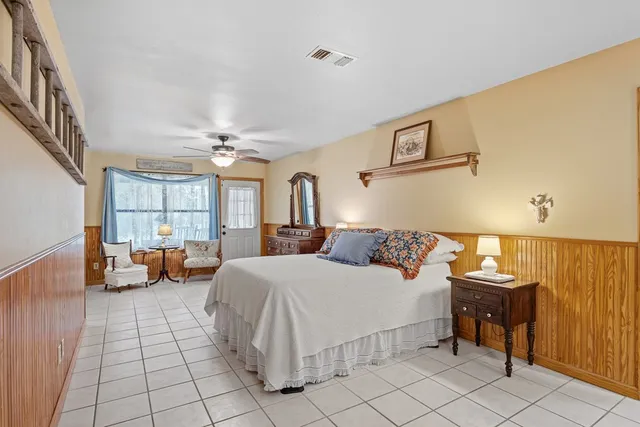 a bedroom with a large bed and a chandelier