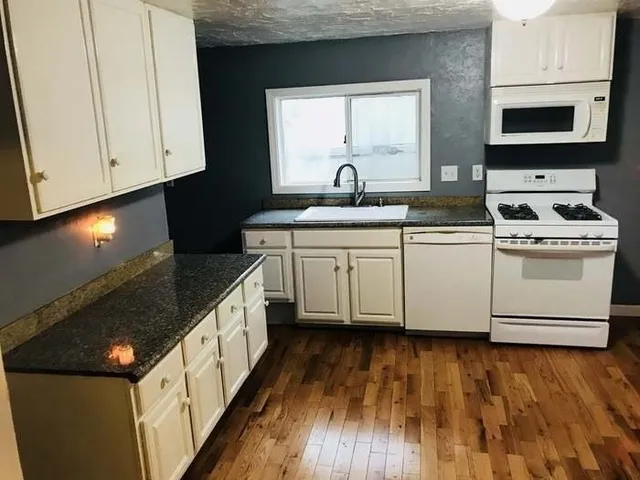 a kitchen with stainless steel appliances granite countertop a stove a sink and a microwave