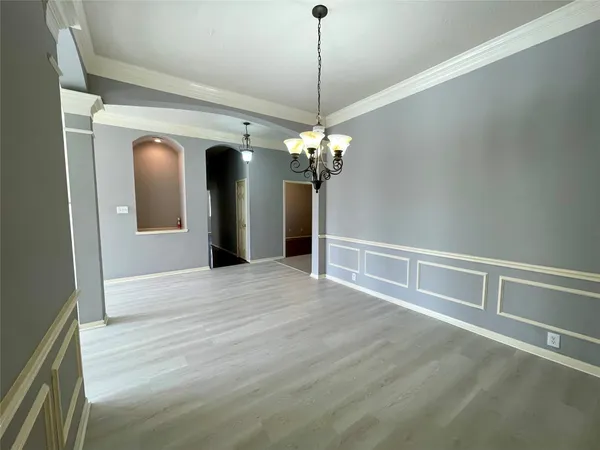 a view of a livingroom with a chandelier fan and windows