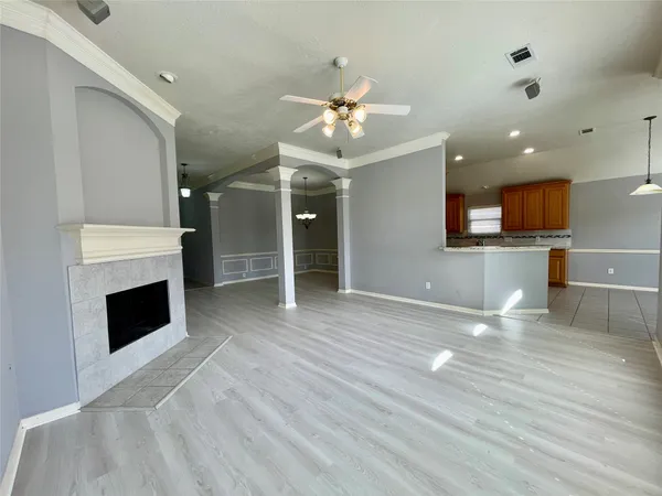 an empty room with wooden floor and chandelier