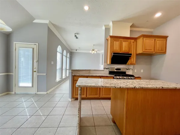a kitchen with granite countertop a stove a sink and a microwave