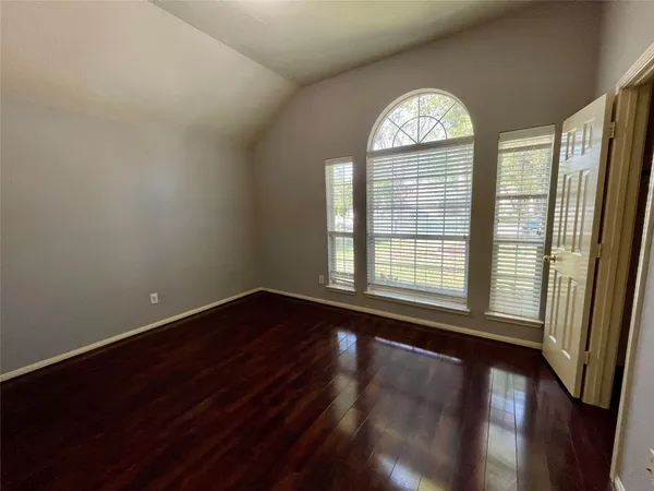 a view of a big room with wooden floor and windows