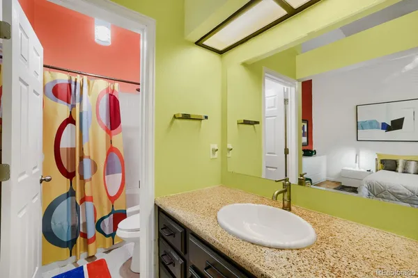 a bathroom with a granite countertop sink and a mirror