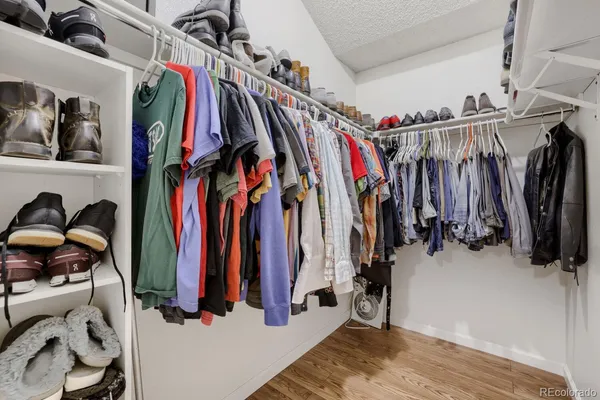 a view of walk in closet with clothes and shoes