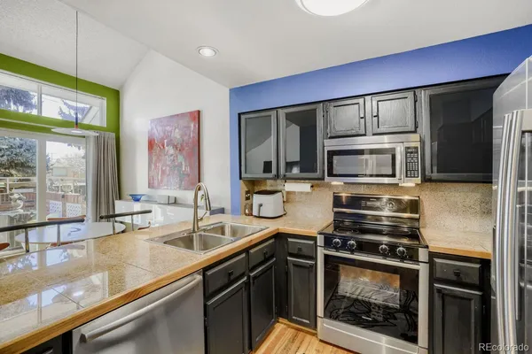 a kitchen with stainless steel appliances a sink cabinets and a window