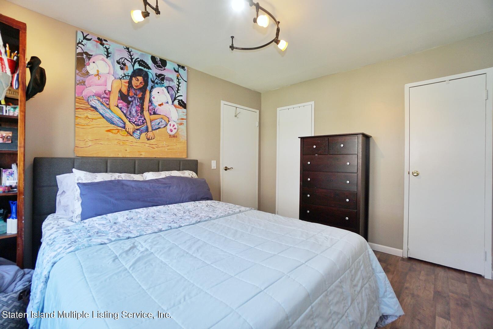 40 Racal Court, Unit B1 Staten Island, NY 10314 - Photo 15 of 16 a bedroom with a bed and painting on the wall