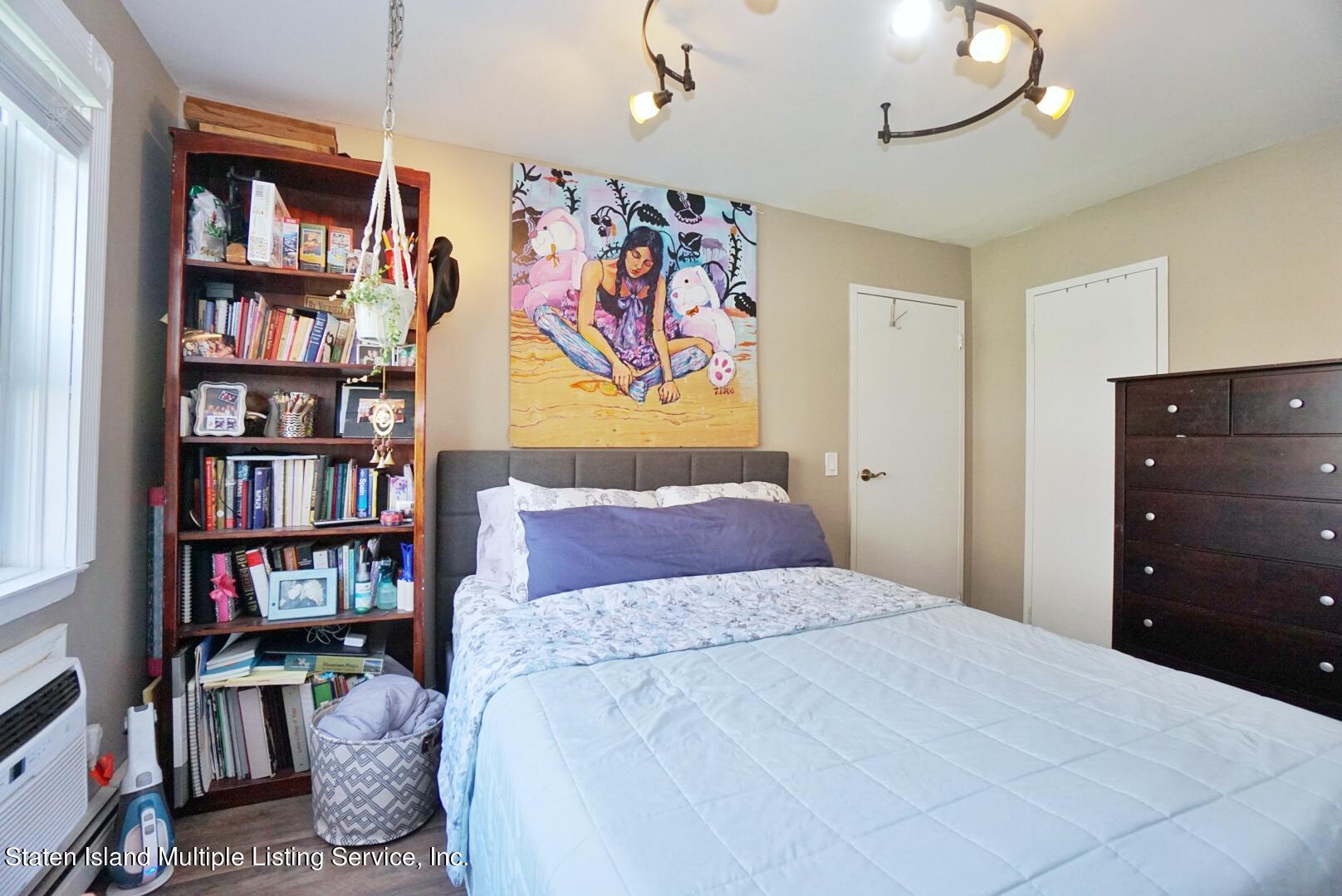40 Racal Court, Unit B1 Staten Island, NY 10314 - Photo 16 of 16 a bedroom with a bed a book shelf and a book shelf