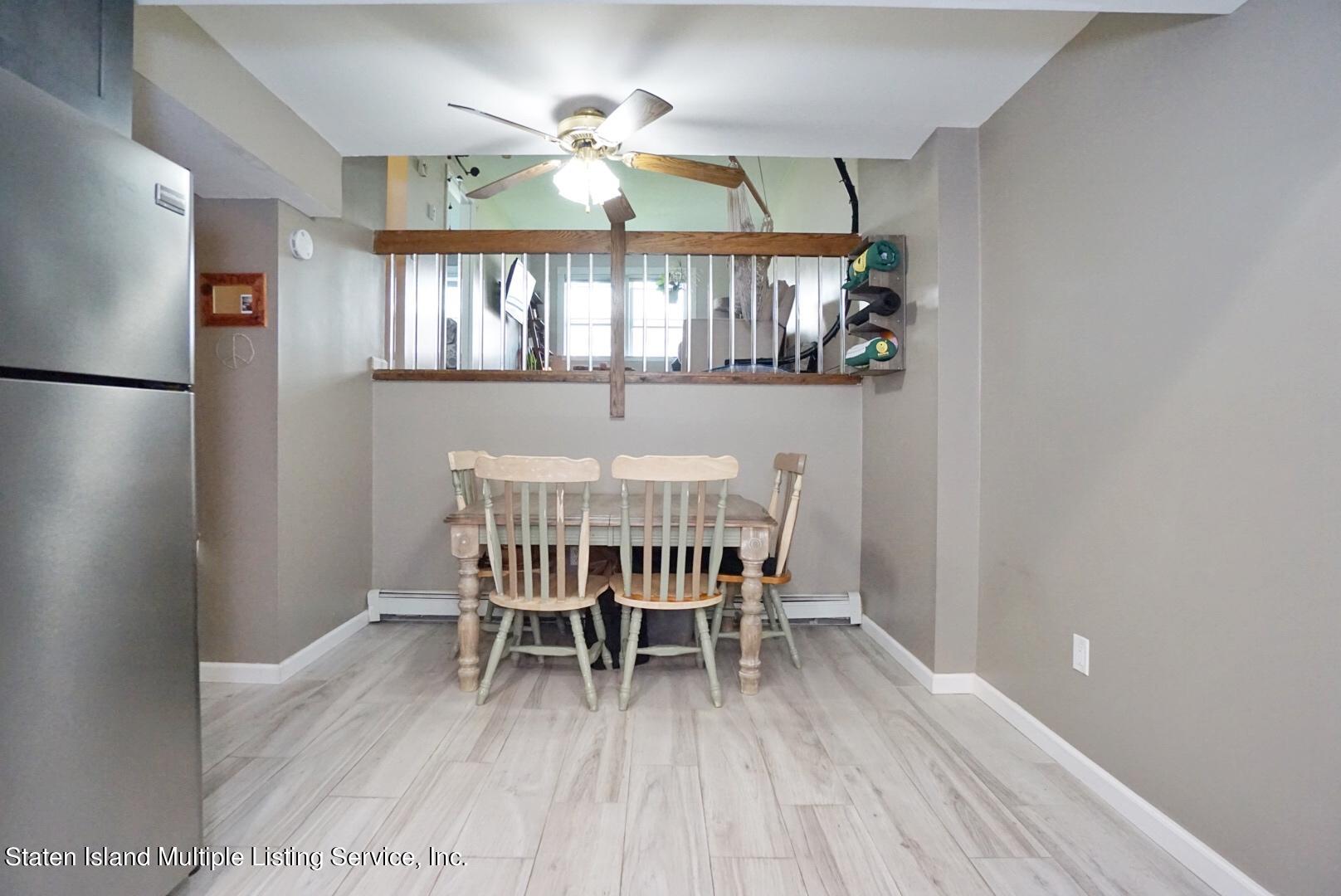 40 Racal Court, Unit B1 Staten Island, NY 10314 - Photo 4 of 16 a dining room with furniture a chandelier and wooden floor