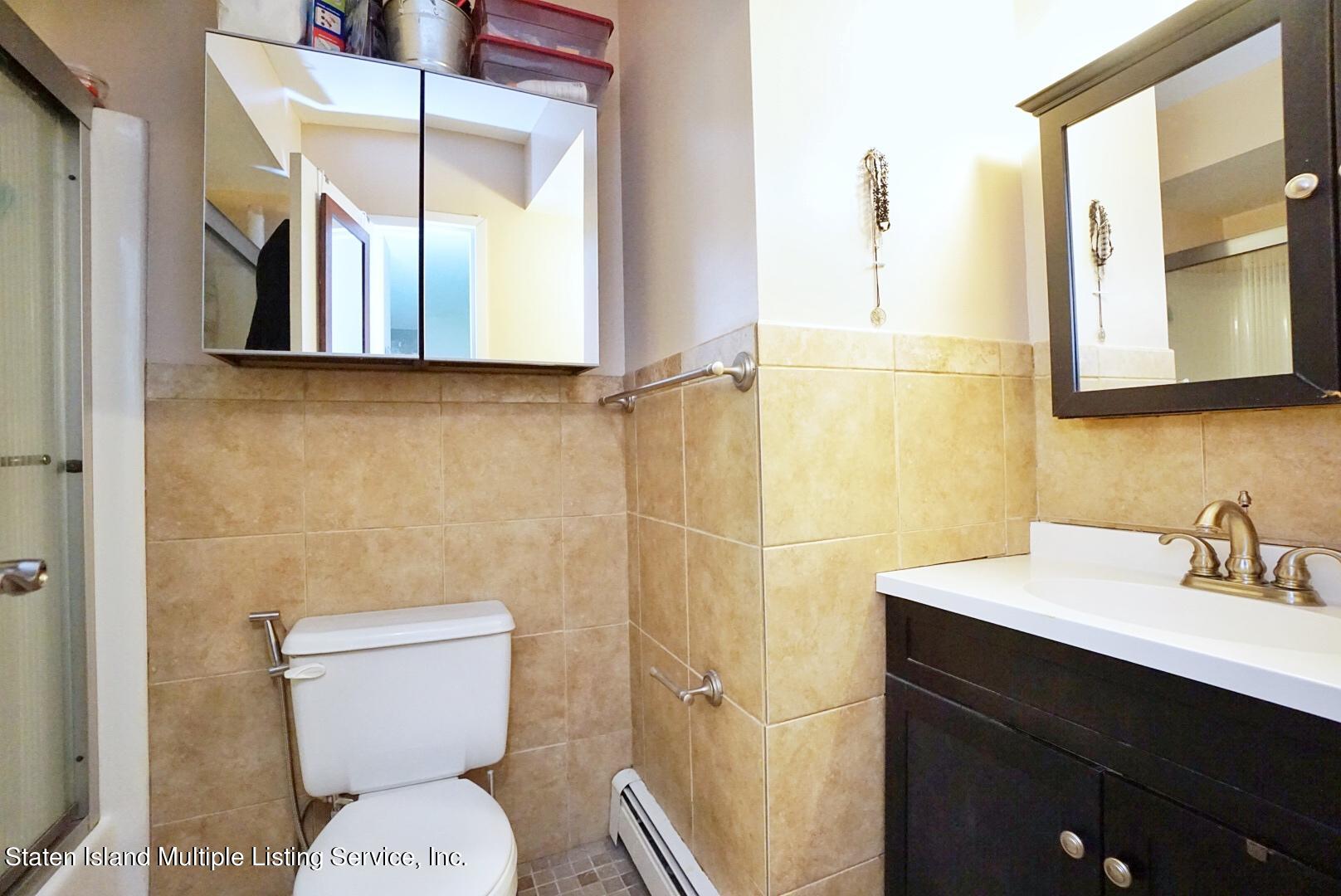40 Racal Court, Unit B1 Staten Island, NY 10314 - Photo 7 of 16 a bathroom with a toilet sink and mirror