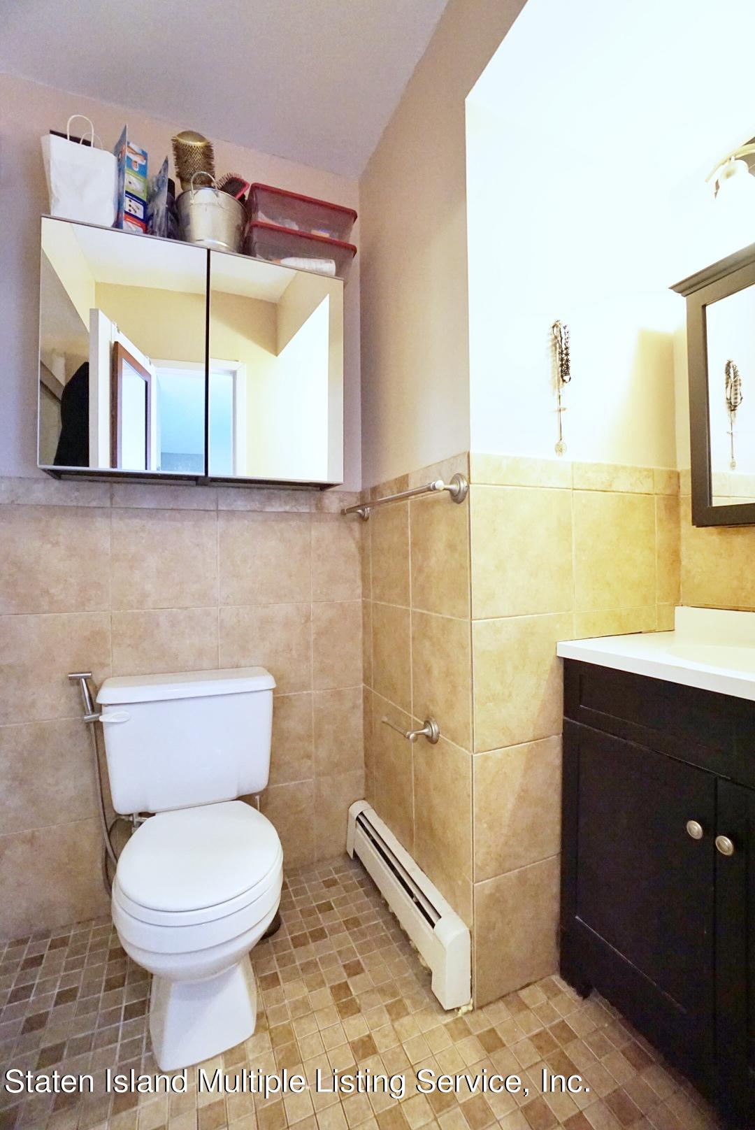 40 Racal Court, Unit B1 Staten Island, NY 10314 - Photo 8 of 16 a bathroom with a toilet sink and mirror