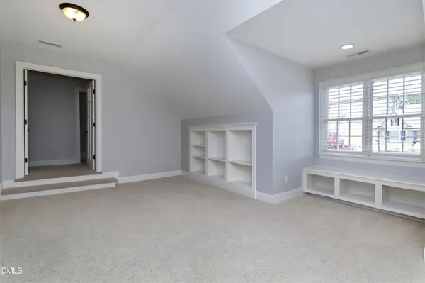 an empty room with windows and cabinet