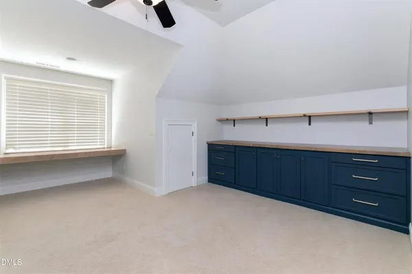 an empty room with a ceiling fan and window