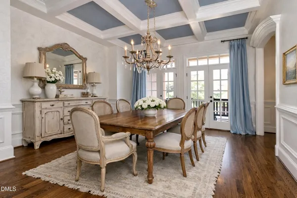 a dining room with furniture a chandelier and wooden floor