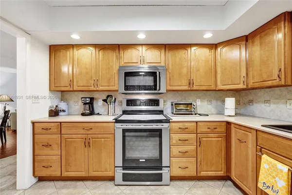 a kitchen with stainless steel appliances a stove sink microwave refrigerator and cabinets