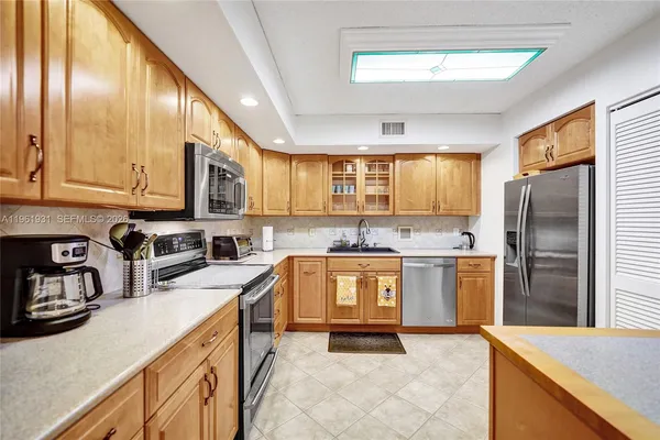a kitchen with stainless steel appliances granite countertop a refrigerator and a stove top oven