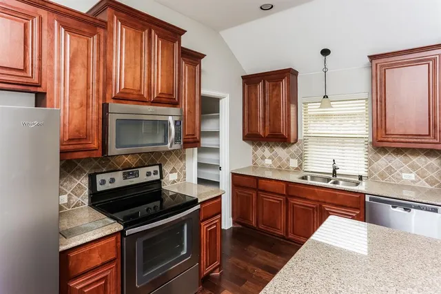 a kitchen with stainless steel appliances granite countertop a stove microwave and sink