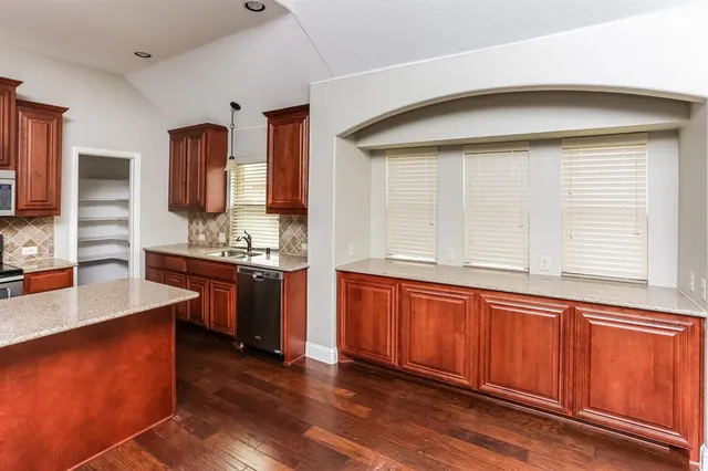 a kitchen with stainless steel appliances granite countertop a sink and a stove
