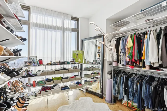 a view of walk in closet with clothes and shoes